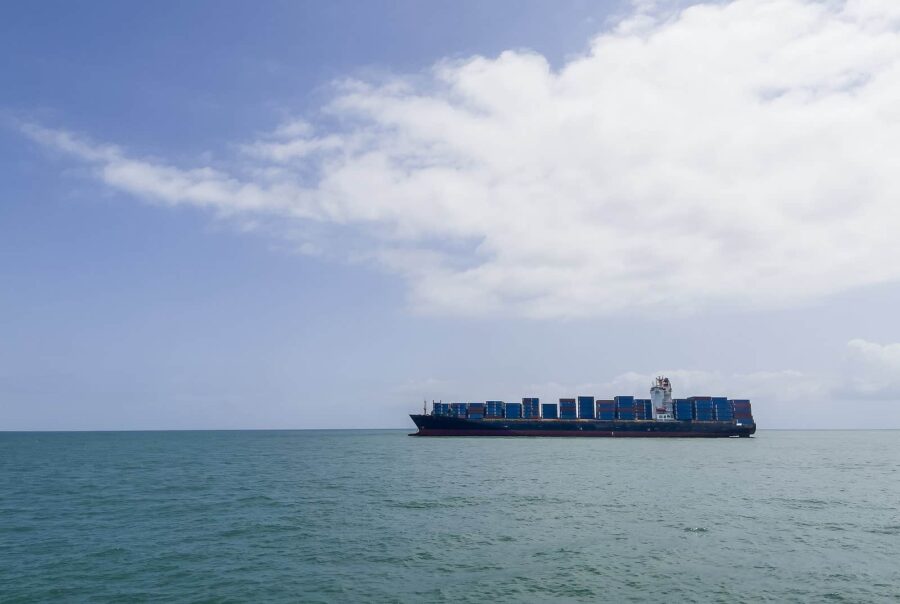 Image of shipping containers on a ship crossing the ocean.